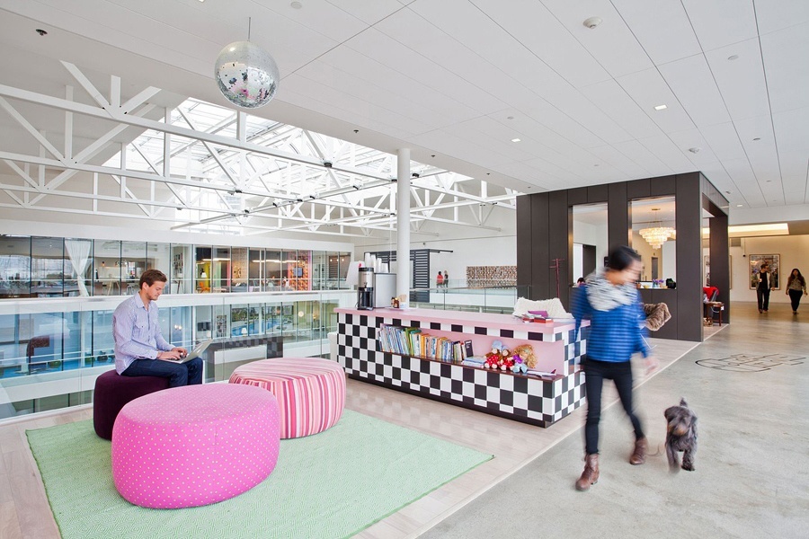 Bureaux lumineux avec poufs roses et coin café, idéaux pour la rentrée