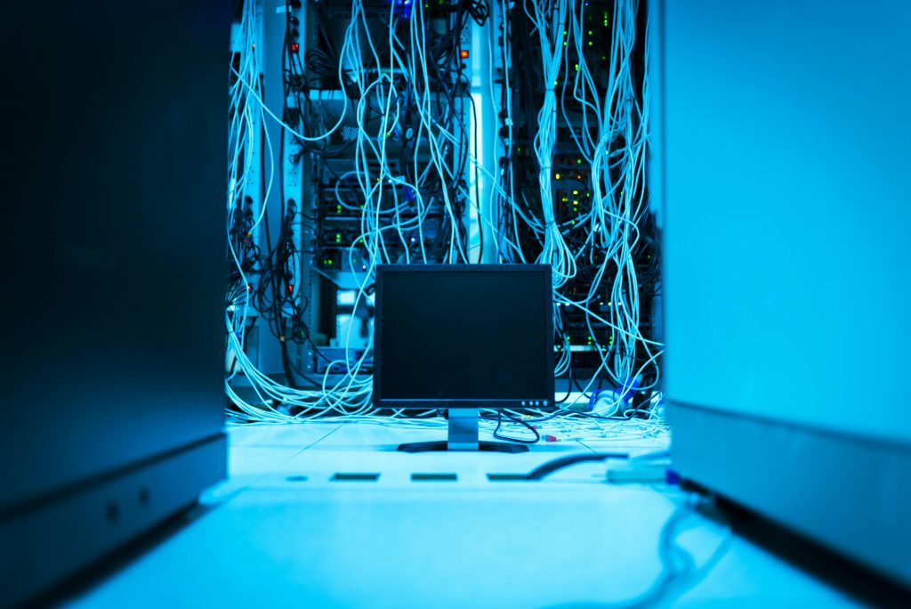 Baie de serveurs et câbles réseau dans une salle informatique
